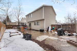 Back of house featuring a fenced backyard, a trampoline, cooling unit, and a patio