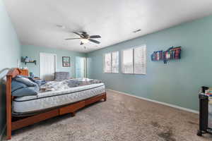 Carpeted bedroom featuring baseboards, and ceiling fan