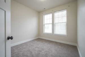 Carpeted empty room with baseboards