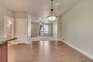 Interior space featuring ceiling fan, baseboards, and wood finished floors