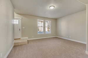 Interior space featuring visible vents, light carpet, and baseboards