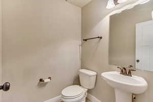 Bathroom with a sink, toilet, and baseboards