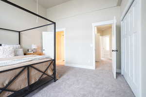 Bedroom with light colored carpet and a closet
