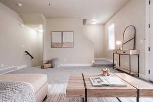 Living area featuring carpet flooring and baseboards