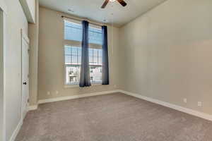 Spare room with carpet, visible vents, ceiling fan, and baseboards