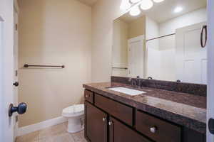Bathroom with vanity, a shower, and tile patterned flooring