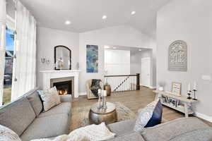 Living area featuring lofted ceiling, recessed lighting, wood finished floors, and a tile fireplace