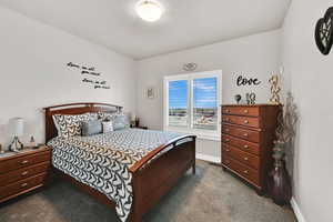 Bedroom with dark colored carpet and baseboards