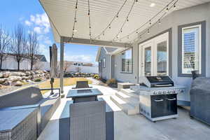 View of patio with an outdoor living space with a fire pit, a grill, and fence