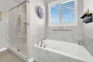 Bathroom with a garden tub and a marble finish shower