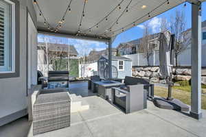 View of patio / terrace featuring a fenced backyard, an outdoor structure, a fire pit, and a shed