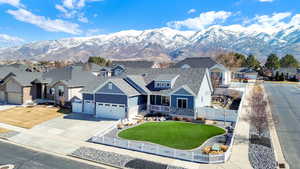 View of front of home with an attached garage, a fenced front yard, board and batten siding, and a front yard