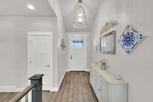 Entrance foyer with light wood-style flooring, visible vents, and baseboards