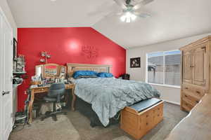 Bedroom featuring vaulted ceiling, ceiling fan, and carpet flooring