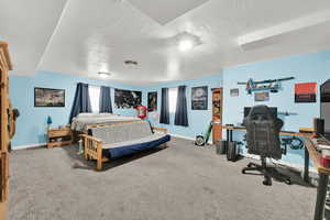 Bedroom with carpet, baseboards, and a textured ceiling