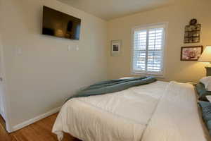 Bedroom featuring baseboards and wood finished floors