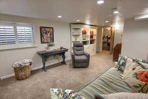 Living room featuring carpet floors, baseboards, and recessed lighting