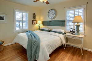 Bedroom with a ceiling fan, baseboards, and wood finished floors