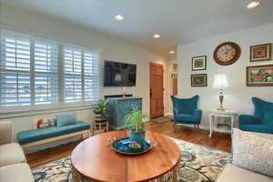 Living area with baseboards, wood finished floors, and recessed lighting