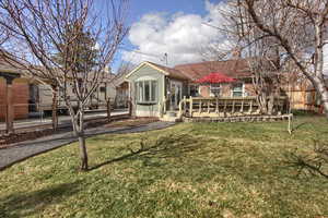 Back of property with a yard, brick siding, and fence