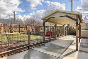 View of home's community with fence private yard and a carport