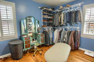 Walk in closet with wood finished floors