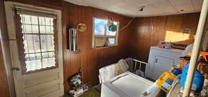 Washroom featuring laundry area and wood walls