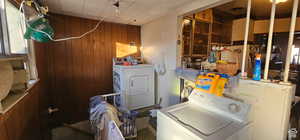 Washroom featuring laundry area, washer and clothes dryer, and wood walls