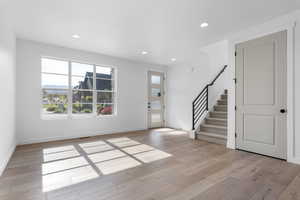 Foyer entrance with light wood-style floors, stairs, baseboards, and recessed lighting