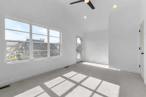 Unfurnished room featuring light carpet, high vaulted ceiling, baseboards, and visible vents
