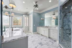 Bathroom featuring marble finish floor, a marble finish shower, and crown molding