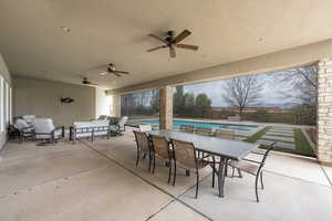 View of patio featuring ceiling fan, a pool with connected hot tub, an outdoor hangout area, and outdoor dining space