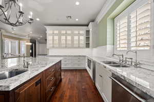 Kitchen featuring white cabinetry, a sink, and stainless steel dishwasher