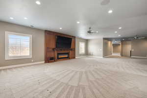 Unfurnished living room featuring light carpet, a fireplace, and recessed lighting