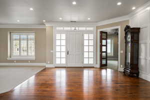 Foyer entrance with recessed lighting, visible vents, hardwood / wood-style floors, ornamental molding, and baseboards