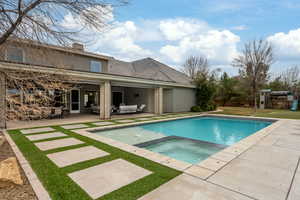 Pool with a lawn, a patio, an in ground hot tub, an outdoor living space, and a playground