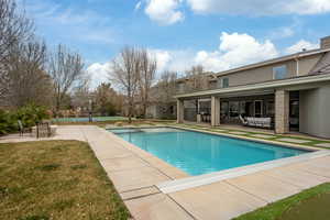 Pool featuring a patio area and a lawn