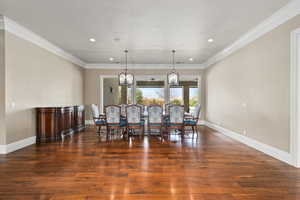 Dining room featuring hardwood / wood-style flooring, baseboards, crown molding, and recessed lighting