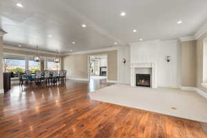 Living area featuring ornamental molding, baseboards, a fireplace, and hardwood / wood-style floors