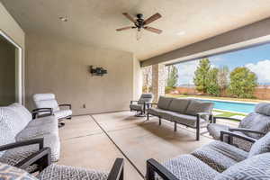 View of patio / terrace with a fenced in pool, a fenced backyard, ceiling fan, and an outdoor living space