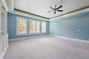 Unfurnished room featuring baseboards, a tray ceiling, and light colored carpet