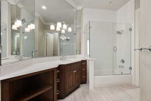 Full bathroom with bath / shower combo with glass door, vanity, and crown molding