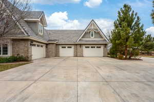 View of property exterior featuring stone siding, driveway, and an attached garage