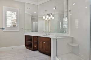 Full bath with a shower with shower door, visible vents, baseboards, vanity, and crown molding