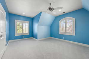 Bonus room featuring baseboards, visible vents, ceiling fan, vaulted ceiling, and carpet floors