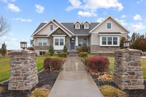 View of front of property featuring a front yard and stone siding