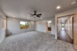 Carpeted empty room with visible vents, baseboards, a ceiling fan, and recessed lighting