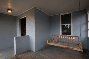 View of front porch featuring covered porch swing