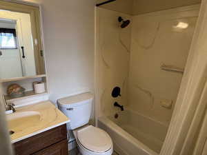 Bathroom featuring bathing tub / shower combination, vanity, and toilet