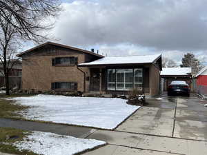 Tri-level home featuring concrete driveway and brick siding